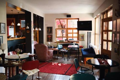 地拉那Red Goat Hostel的客厅配有桌椅和电视