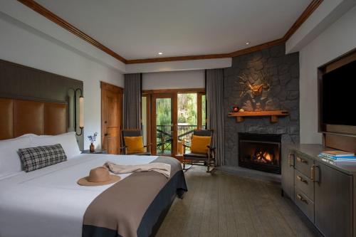 范尔The Hythe, a Luxury Collection Resort, Vail的酒店客房配有一张床和一个壁炉。