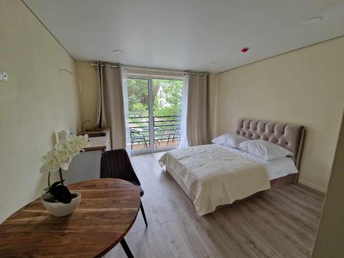 帕兰加2rest的一间卧室配有一张床、一张桌子和一个窗户。