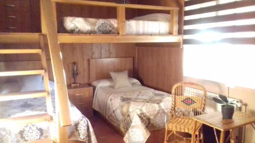 Las LaboresLOS ARCOS的一间卧室配有双层床、一张床和一把椅子