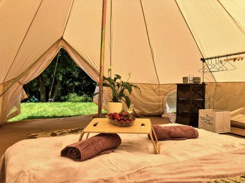 克鲁克兰基Mazury Glamping Kruklanki Polana Życzeń的帐篷,配有桌子和一碗水果