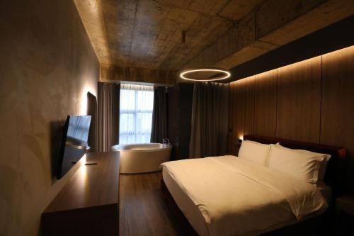 波格拉德茨Toka Hotel Restaurant的卧室配有床、浴缸和窗户。