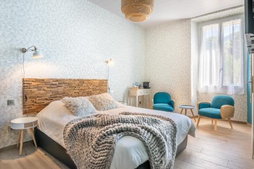 La Chambrele clos grillet的一间卧室配有一张床和两张蓝色椅子
