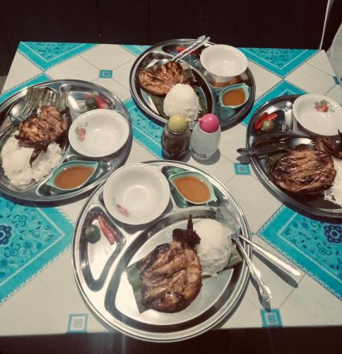 TubigonBossing Inasal的一张桌子,上面放着几盘食物