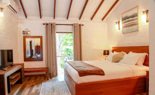 锡吉里亚Tepraas Sigiriya的一间卧室配有一张床、一台电视和一个窗口