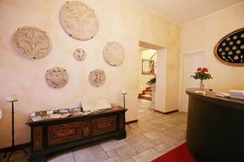 贝加莫瓦莱塔勒莱斯酒店的墙上有桌子和盘子的房间