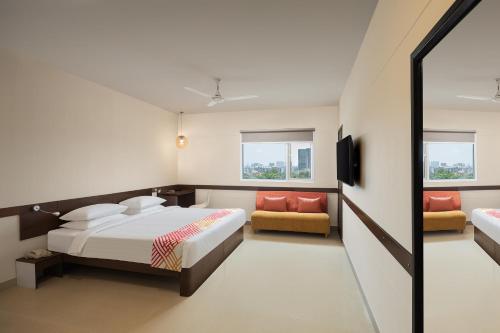 孟买Ginger Mumbai Andheri (MIDC)的一间卧室配有一张床、一张沙发和一台电视。