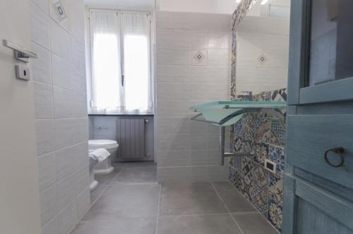 皮昂比诺The Breeze Way的一间带水槽和卫生间的浴室以及窗户。