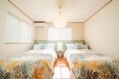 冲绳岛市SHIOYA STAY的一间卧室设有两张床和窗户。
