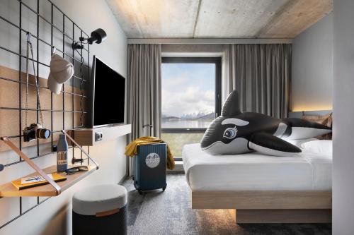 特罗姆瑟Moxy Tromso的一间卧室设有一张床和一个大窗户