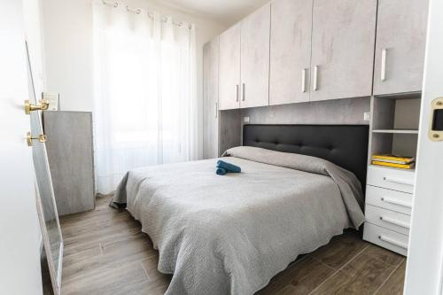卡利亚里SeRa Suite的一间卧室配有一张带白色橱柜的大床