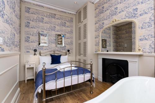 伦敦Bower House的一间卧室配有蓝色和白色壁纸的床