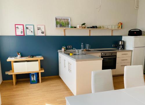 皮尔纳Studio mit Küche的厨房配有白色橱柜和蓝色的墙壁