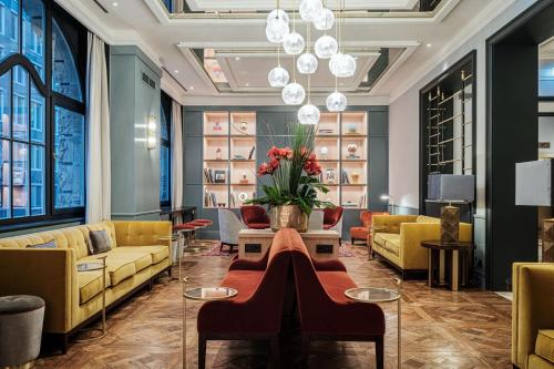 美因河畔法兰克福LUME Boutique Hotel, Autograph Collection的大堂设有黄色的沙发和带鲜花的桌子