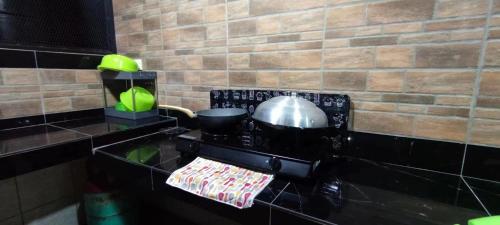 古达S99 HOMESTAY KUDAT的厨房配有带锅碗瓢盆的炉灶