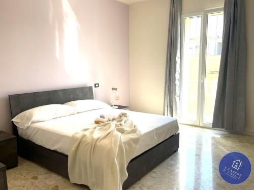 莫拉-迪巴里I CASERE D V'NGINZ - HOLIDAYS APARTMENTS的一间卧室配有一张带白色床单的床和一扇窗户。