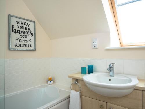 阿维莫尔Eagle Lodge - Aviemore Lodges的浴室配有盥洗盆和浴缸。