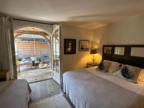 滨海卡瓦莱尔Le Clos des Sept Palmiers的一间卧室设有一张床,并有通往庭院的门