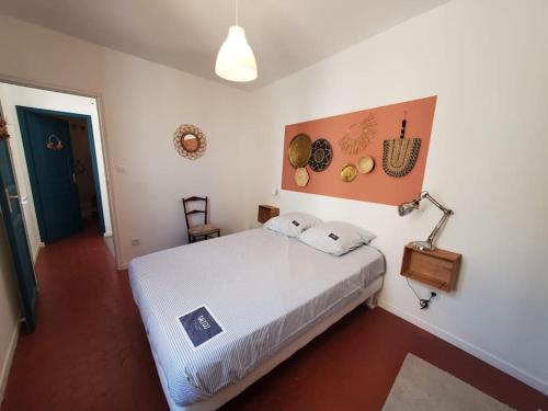 纳博讷La Louve - maison de ville的卧室配有白色大床和灯