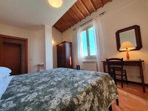 锡耶纳马里迪亚纳酒店的一间卧室配有一张床、一张桌子和一面镜子