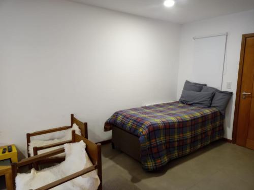 圣马丁德洛斯Hermoso Departamento Céntrico en San Martin de los Andes的一间卧室配有一张床、一张床和一把椅子