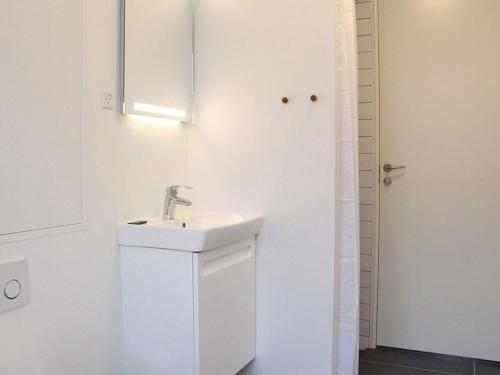 斯瓦讷克Holiday home Svaneke XLI的白色的浴室设有水槽和门
