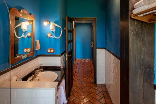 纳隆河畔穆罗斯Globales Playa de Las Llanas的带浴缸、水槽和蓝色墙壁的浴室