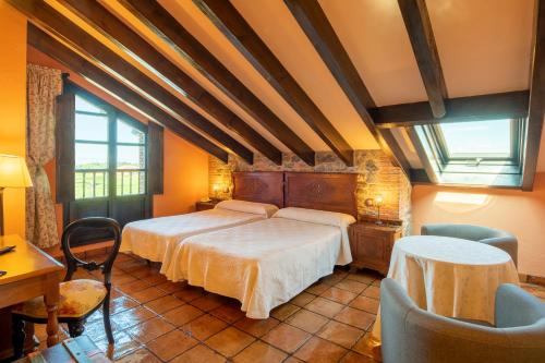 纳隆河畔穆罗斯Globales Playa de Las Llanas的卧室配有一张床和一张桌子及椅子