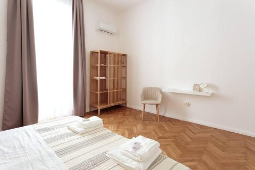 普拉Central Pula - Charming Historic Gem - Modern Comforts的白色的客房设有两张床、一张桌子和一个窗户。