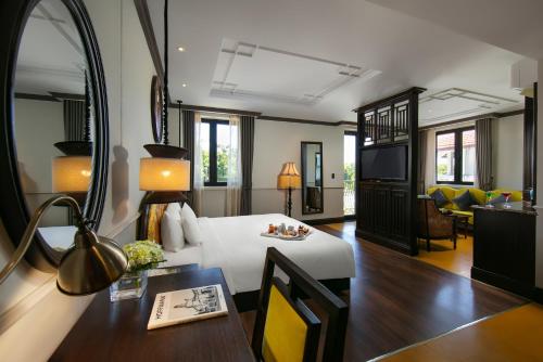 会安Silkian Hoian Boutique Hotel & Spa的酒店客房 - 带一张床和用餐室