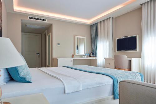格克切达镇Meydani Butik Hotel的酒店客房,配有床和电视