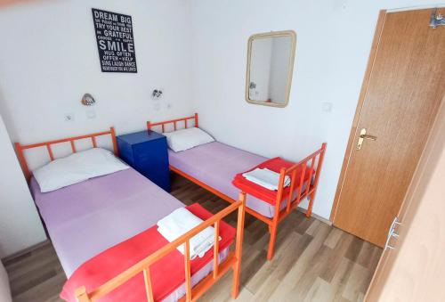 耶泽尔采Plitvice RH Hostel Rooms的配有镜子和门的客房内的两张床