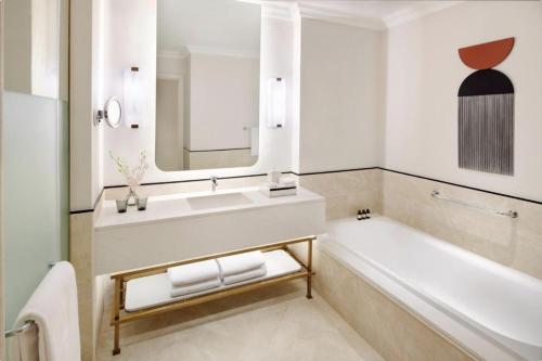 阿莱曼Address Marassi Golf Resort Hotel Appartments的带浴缸、水槽和镜子的浴室