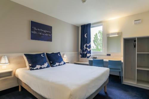 泰昂维ACE Hôtel Thionville - Porte du Luxembourg的卧室配有带蓝色枕头的大型白色床