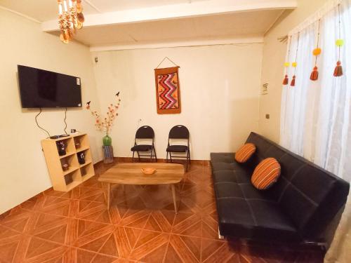 圣佩德罗·德·阿塔卡马Casa Sutar Los Pimientos的客厅配有黑色沙发和桌子