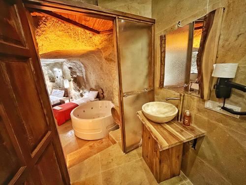 NarAsma Altı Cave Suit's的一间带水槽、浴缸和镜子的浴室