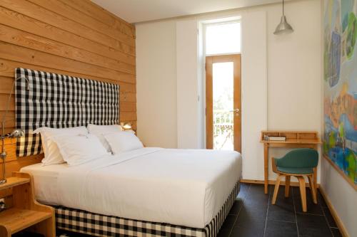 塞卡尔荷达德马迪哈乡村别墅＆餐厅的卧室配有一张白色大床和一把椅子