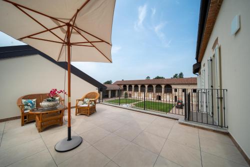 TerruggiaCascina Baronina的庭院配有遮阳伞和桌椅。