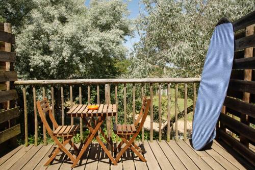 塞卡尔荷达德马迪哈乡村别墅＆餐厅的甲板上配有一张桌子和两把椅子以及冲浪板