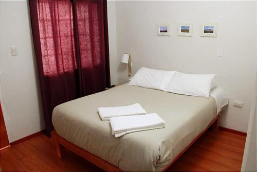 阿雷基帕COLONIAL SAN LAZARO的一间卧室配有一张床,上面有两条毛巾
