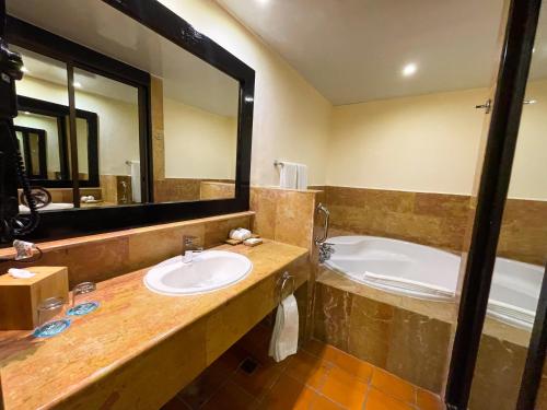蓬塔卡纳蓬塔卡纳加泰罗尼亚全包酒店的一间带水槽、浴缸和镜子的浴室