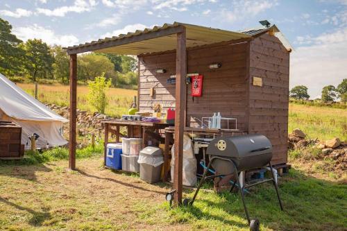 Upper HulmeRoaches Retreat Eco Glampsite - Rocky Reach Bell Tent的小屋前的烧烤和烧烤