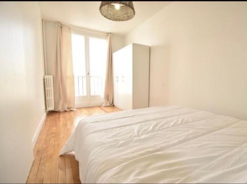 奥贝维利埃Superbe appartement cosy Paris/Stade de France的白色卧室内的一张白色床,设有窗户