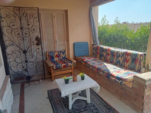 Qaryat Shurūqشاليه دور ارضى مدخل خاص يرى البحر的客厅配有沙发和椅子,阳台