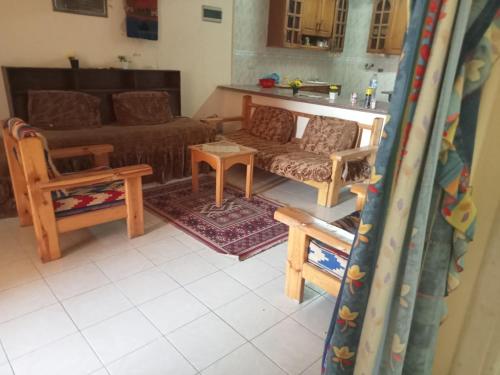 Qaryat Shurūqشاليه دور ارضى مدخل خاص يرى البحر的客厅配有沙发和桌子