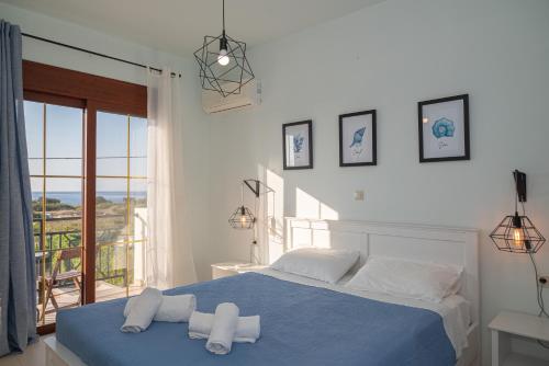 根纳迪佩特拉别墅的一间卧室配有蓝色的床和毛巾