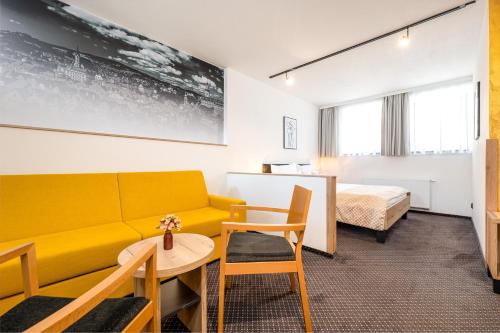 捷克克鲁姆洛夫Penzion Golden Crown的客厅配有黄色的沙发和床。