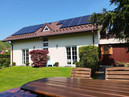什切尔克Molonówka Guest House的屋顶上设有太阳能电池板的房子