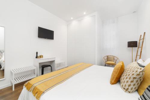 法蒂玛LUMO Flat Fátima的一间白色卧室,配有一张床和一个壁炉