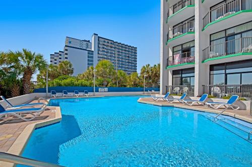 默特尔比奇Ocean Park Resort - Oceana Resorts Vacation Rentals的一座带躺椅的游泳池和一座建筑